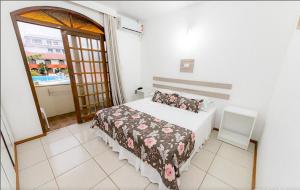 a bedroom with a bed and a large window at Acqua Floripa Morro das Pedras SC in Florianópolis
