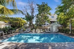 uma piscina num quintal com cadeiras e uma cerca em The Oceans Cozy 1BR Apartment in Victoria Park with Pool em Fort Lauderdale