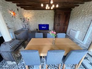a table with chairs and a vase of flowers on it at Gîte climatisé avec jacuzzi privé & terrasse - jusqu'à 7 pers entre Blois et Amboise in Chouzy-sur-Cisse