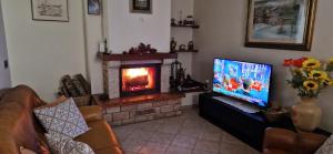 uma sala de estar com televisão e lareira em Casa Lichio em Stia
