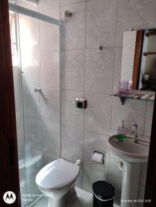 a bathroom with a shower and a toilet and a sink at Kit net para casal in Ubatuba