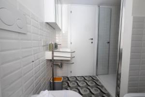 a white bathroom with a shower and a toilet at La Cupola Apartment in Rome