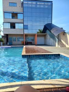 een zwembad voor een gebouw bij Apartamento completo praia do sonho in Palhoça