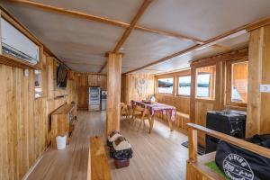 Holzhütte mit einem Tisch und einem Esszimmer in der Unterkunft Phinisi Boat Maheswari Komodo in Labuan Bajo