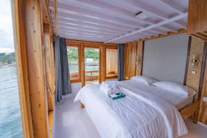 a bedroom with a bed with a tray on it at Phinisi Boat Maheswari Komodo in Labuan Bajo