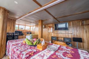 Zimmer mit einem Tisch und einer Schale Bananen in der Unterkunft Phinisi Boat Maheswari Komodo in Labuan Bajo