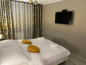 a bedroom with a bed with two yellow pillows on it at Apartament CITY Ustroń in Ustroń