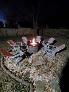 un groupe de chaises autour d'un foyer extérieur la nuit dans l'établissement Time To Relax in Raleigh, à Raleigh