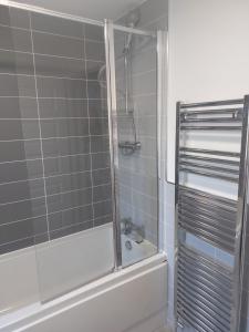 uma casa de banho com um chuveiro e uma cabina de duche em vidro. em Beautiful 4-Bedroom House with Private Garden & Parking em Edimburgo