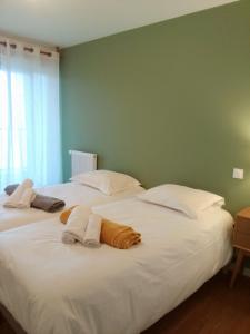 2 große Betten in einem Zimmer mit grünen Wänden in der Unterkunft Zenao Appart'hôtels Boulogne-sur-Mer - La Rose des Vents in Boulogne-sur-Mer