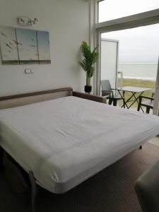 un grande letto in una camera con vista sull'oceano di Zee en Zicht a De Panne