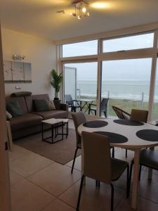 sala de estar con sofá, mesa y sillas en Zee en Zicht, en De Panne