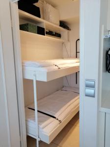 a small room with white bunk beds at Zee en Zicht in De Panne
