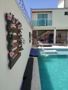 a house with a swimming pool with flowers on the wall at Espaço Lux Betim in Betim