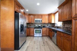 a kitchen with wooden cabinets and stainless steel appliances at Beautiful Spacious Home in Los Angeles