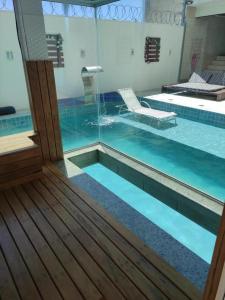 a swimming pool with a glass door and a swimming pool at Espaço Lux Betim in Betim