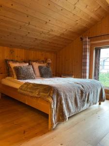 Cama grande en habitación con techo de madera en Le Mazot Alice, en Vercorin