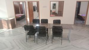 una mesa de comedor con sillas negras en una habitación en Pushkar Mountain Resort, en Pushkar