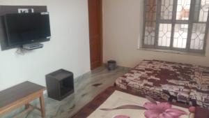 Habitación con cama y TV de pantalla plana. en Pushkar Mountain Resort, en Pushkar