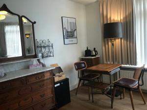 een kamer met een bureau en een tafel en stoelen bij Bed and Breakfast Rotterdam in Rotterdam
