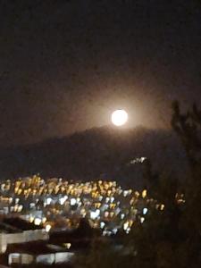 - une vue sur une ville la nuit avec la lune dans l'établissement Casa Salkantay Mini Departamento, à Cusco