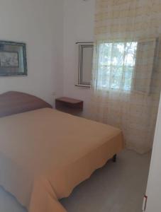 a bedroom with a bed and a window at Perla Marina in Peschici