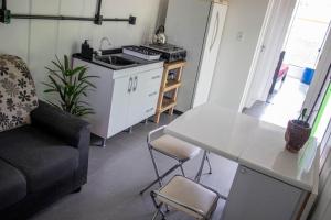 a kitchen with a couch and a table in a room at Casa Container á 3minutos da Lagoa in Tapes