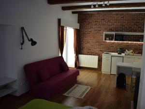 a living room with a red couch and a brick wall at BrasovApart Republicii in Braşov