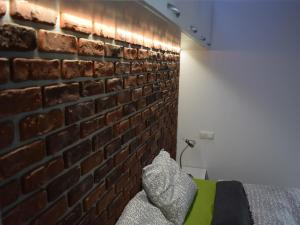 a brick wall in a bedroom with a green couch at BrasovApart Republicii in Braşov