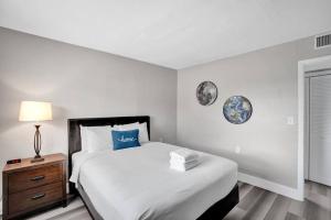 a bedroom with a large bed and a nightstand with a bed sidx sidx sidx at Pionciana Getaway 1BR Apartment Near FLL Airport in Fort Lauderdale