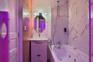 La salle de bains est pourvue d'un lavabo, d'une baignoire et d'un miroir. dans l'établissement UnSejourAMetz - Le mille et une nuits, à Metz