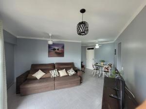 uma sala de estar com um sofá e uma mesa em Maravilhoso apto à beira-mar em Caraguatatuba