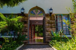 Gypsy Guest House Clarens في كلارينس: بيت حجري بباب احمر واضاءين