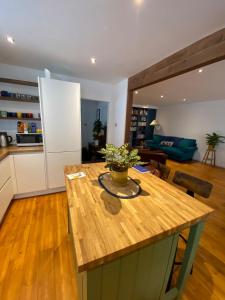 Modern 1BD Farmhouse-Style Flat - Dalston! في لندن: مطبخ وغرفة معيشة مع كونتر خشبي علوي