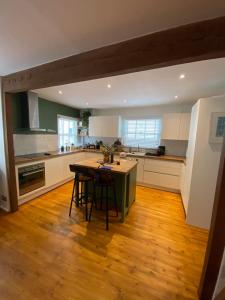 Modern 1BD Farmhouse-Style Flat - Dalston! في لندن: مطبخ مع أرضية خشبية وطاولة