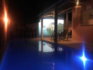 uma piscina à noite com vista para a água em B&B Beach House Pousada Exclusiva pés na água Pontal do Peba única em Alagoas em Pontal do Peba