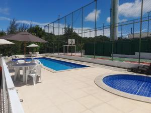 a swimming pool with a table and a basketball hoop at Apartamento flat em condomínio club in Aracaju