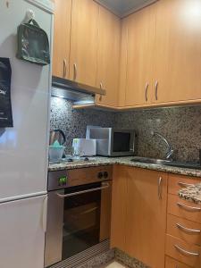 a kitchen with a white refrigerator and a microwave at Moderno apartamento con encanto en el centro de Vigo in Vigo