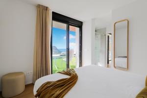 um quarto com uma cama e uma grande janela em Agaete Penthouse Bliss Views em Puerto de las Nieves