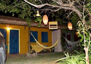 a yellow house with a hammock in front of it at Res. Orion Praia do Espelho in Praia do Espelho