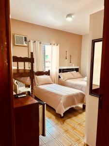 a bedroom with two beds and a window at Pousada Amanhecer do Itaguá in Ubatuba