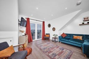 a living room with a blue couch and a window at Portstewart Central Loft Apartment in Portstewart