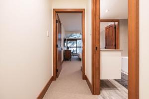 a hallway with a door leading into a room at Snowberry by Outpost Whistler in Whistler