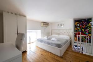 ein weißes Schlafzimmer mit einem Bett und einem Stuhl in der Unterkunft La Cupola Apartment in Rom