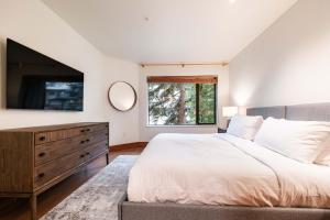 um quarto com uma cama grande e uma janela grande em Snowberry by Outpost Whistler em Whistler