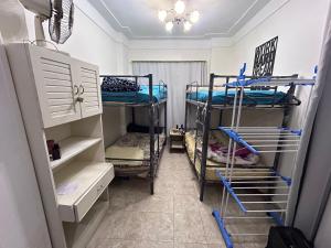 een kamer met 3 stapelbedden in een kamer bij Victoria Hostel in Alexandrië