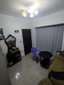 een woonkamer met een blauwe stoel en een tafel bij Victoria Hostel in Alexandrië