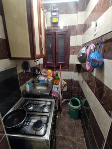 een kleine keuken met een fornuis en een wastafel bij Victoria Hostel in Alexandrië