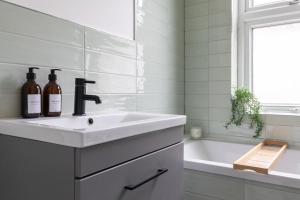un bagno bianco con lavandino e vasca di Beautiful 3BR Flat with Desks and Fast Wi-Fi a Londra