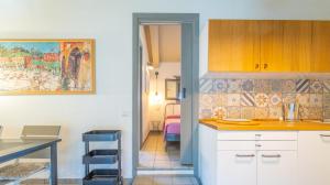 een keuken met witte kasten en een kamer met een bed bij Podere Spartaco San Pantaleo in San Pantaleo